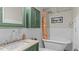 Elegant bathroom featuring a clawfoot tub, granite countertop, and green cabinetry at 3070 Cameron Dr, Henderson, NC 27536