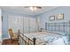 Light-filled bedroom with blue walls, ceiling fan, hardwood floors, and a cozy bed with decorative quilt at 3070 Cameron Dr, Henderson, NC 27536