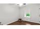 Simple bedroom with hardwood floors, light walls, and a large window, offering a serene view of the outside at 3070 Cameron Dr, Henderson, NC 27536