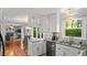 Bright kitchen features white cabinetry, granite countertops, stainless steel appliances, and hardwood flooring at 3070 Cameron Dr, Henderson, NC 27536