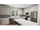 Bright kitchen featuring stainless steel appliances, white cabinetry, a breakfast bar, and a window with views of the outdoors at 338 Cottage Hill Way, Knightdale, NC 27604