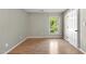 Bedroom featuring a window, light walls, wood floor, and a white door to another room at 3427 Mill Run, Raleigh, NC 27612