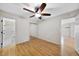 Bright bedroom featuring wood floors, neutral walls, ceiling fan, and closet with mirrored doors at 3427 Mill Run, Raleigh, NC 27612
