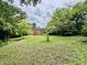 Spacious backyard featuring mature trees and a fire pit at 405 Foster Ln, Burlington, NC 27215
