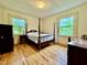 Bedroom with wood floors, natural light, and views of greenery outside at 405 Foster Ln, Burlington, NC 27215
