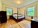Bedroom with wood floors, natural light, and views of greenery outside at 405 Foster Ln, Burlington, NC 27215