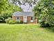 Inviting brick home with manicured bushes and lush green grass at 405 Foster Ln, Burlington, NC 27215
