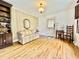 Living room with hardwood floors, built-in shelving, vintage sofa, and natural light from a side window at 405 Foster Ln, Burlington, NC 27215