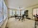 Sunroom with large windows offering ample natural light, neutral carpet, and a ceiling fan at 405 Foster Ln, Burlington, NC 27215