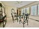 Sunroom features neutral carpet, ceiling fan, and an elegant dining set with views from multiple windows at 405 Foster Ln, Burlington, NC 27215
