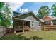 Back exterior showing the deck, backyard, gray siding, and string lights with mature trees at 415 1St St, Apex, NC 27502