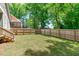 Large, well-maintained backyard with a wooden fence, lush grass, and mature trees at 415 1St St, Apex, NC 27502