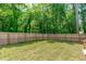 Large, well-maintained backyard features a wooden fence, lush grass, and mature trees at 415 1St St, Apex, NC 27502