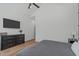 Bedroom featuring a ceiling fan, wood floor, accent wall with a TV, and a dresser at 415 1St St, Apex, NC 27502