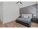 Spacious bedroom with a wood floor, vaulted ceiling, stylish accent wall, and a comfortable king-size bed at 415 1St St, Apex, NC 27502