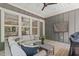 Relaxing covered porch with ceiling fan, TV, wicker seating with a gray painted wood paneling at 415 1St St, Apex, NC 27502