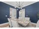 Dining room with dark blue accent wall, modern chandelier, and open access to other rooms at 415 1St St, Apex, NC 27502