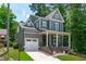 Attractive two-story home with gray siding, a front porch, white trim, and an attached garage at 415 1St St, Apex, NC 27502