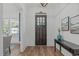 Bright foyer with hardwood floors, front door with glass, stylish console table, and white walls at 415 1St St, Apex, NC 27502