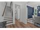 Hallway featuring hardwood floors, staircase, leading to dining room with blue accent wall at 415 1St St, Apex, NC 27502