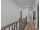Upstairs hallway featuring wood floors, wooden railing, access to bedrooms and closets at 415 1St St, Apex, NC 27502