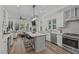 Open concept kitchen with white cabinets, stainless steel appliances, kitchen island, and breakfast bar at 415 1St St, Apex, NC 27502