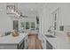 Bright kitchen area with stainless steel appliances, white cabinets, gray backsplash, and a center island with quartz countertops at 415 1St St, Apex, NC 27502