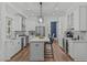 Spacious kitchen with stainless steel appliances, white cabinets, gray backsplash, a center island, and an adjacent dining area at 415 1St St, Apex, NC 27502