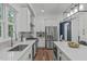 Bright kitchen featuring stainless steel appliances, white cabinets, gray backsplash, and a center island with quartz countertops at 415 1St St, Apex, NC 27502