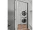 Modern laundry room with stacked washer and dryer, custom cabinets and a bench at 415 1St St, Apex, NC 27502