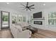 Bright living room with a fireplace, white shiplap, an entertainment center, and a door to the backyard at 415 1St St, Apex, NC 27502