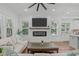 Inviting living room with a fireplace, white shiplap, an entertainment center, and view of the kitchen with center island at 415 1St St, Apex, NC 27502