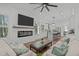 Bright living room with a fireplace, white shiplap, an entertainment center and an open view of the kitchen and island at 415 1St St, Apex, NC 27502