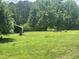 Grassy backyard with fencing and storage beside the house at 4796 Covered Bridge Rd, Archer Lodge, NC 27527