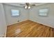 Bright bedroom features hardwood floors, two windows, ceiling fan, and neutral walls at 4796 Covered Bridge Rd, Archer Lodge, NC 27527