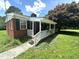 Inviting front porch with white railing, brick siding, and a well-manicured lawn at 4796 Covered Bridge Rd, Archer Lodge, NC 27527