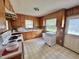 Functional kitchen with wood cabinets, vintage-style flooring, and backyard view at 4796 Covered Bridge Rd, Archer Lodge, NC 27527
