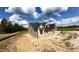New construction home with a black roof, tan siding, and stone accents, complemented by a spacious, sunny lot at 5008 Hopkins Chapel Rd, Zebulon, NC 27597