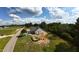 Aerial view of a new home with gray siding and roof situated near a quiet road and farm fields at 5009 Hopkins Chapel Rd, Zebulon, NC 27597