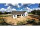 Newly constructed home with light gray siding, a dark shingle roof and an unfinished back porch at 5009 Hopkins Chapel Rd, Zebulon, NC 27597