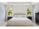 Primary bedroom featuring a tufted headboard, side tables, and natural light at 604 Nottely Pl, Cary, NC 27519