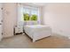 Bedroom boasting a white bed, a nightstand, and a window view of lush trees at 604 Nottely Pl, Cary, NC 27519