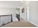 Upstairs hallway with carpet, dark wood railing, and neutral walls and trim at 604 Nottely Pl, Cary, NC 27519