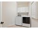 Laundry room showcasing a front load washer and dryer with white cabinetry above at 604 Nottely Pl, Cary, NC 27519