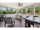 Bright sunroom with tile flooring, ceiling fan, and views of the well manicured backyard at 604 Nottely Pl, Cary, NC 27519