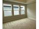 Spacious bedroom featuring neutral carpeting and three large windows allowing plenty of natural light at 64 Rainfall Dr, Pittsboro, NC 27312