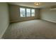 Expansive bonus room boasts neutral carpeting and three large windows offering views at 64 Rainfall Dr, Pittsboro, NC 27312