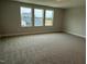 Bright and airy bonus room featuring three large windows and neutral carpet at 64 Rainfall Dr, Pittsboro, NC 27312