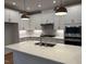 The modern kitchen includes stainless steel appliances, white cabinets and a quartz countertop island at 64 Rainfall Dr, Pittsboro, NC 27312