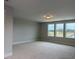 A spacious living room with carpet flooring and multiple windows at 64 Rainfall Dr, Pittsboro, NC 27312